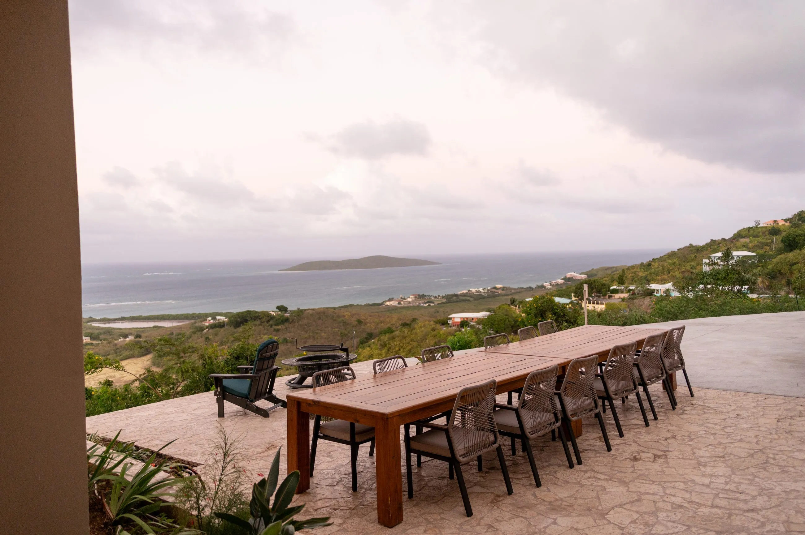 The terrace dining table set for twelve, looking out over the hills to Buck Island and the open Caribbean